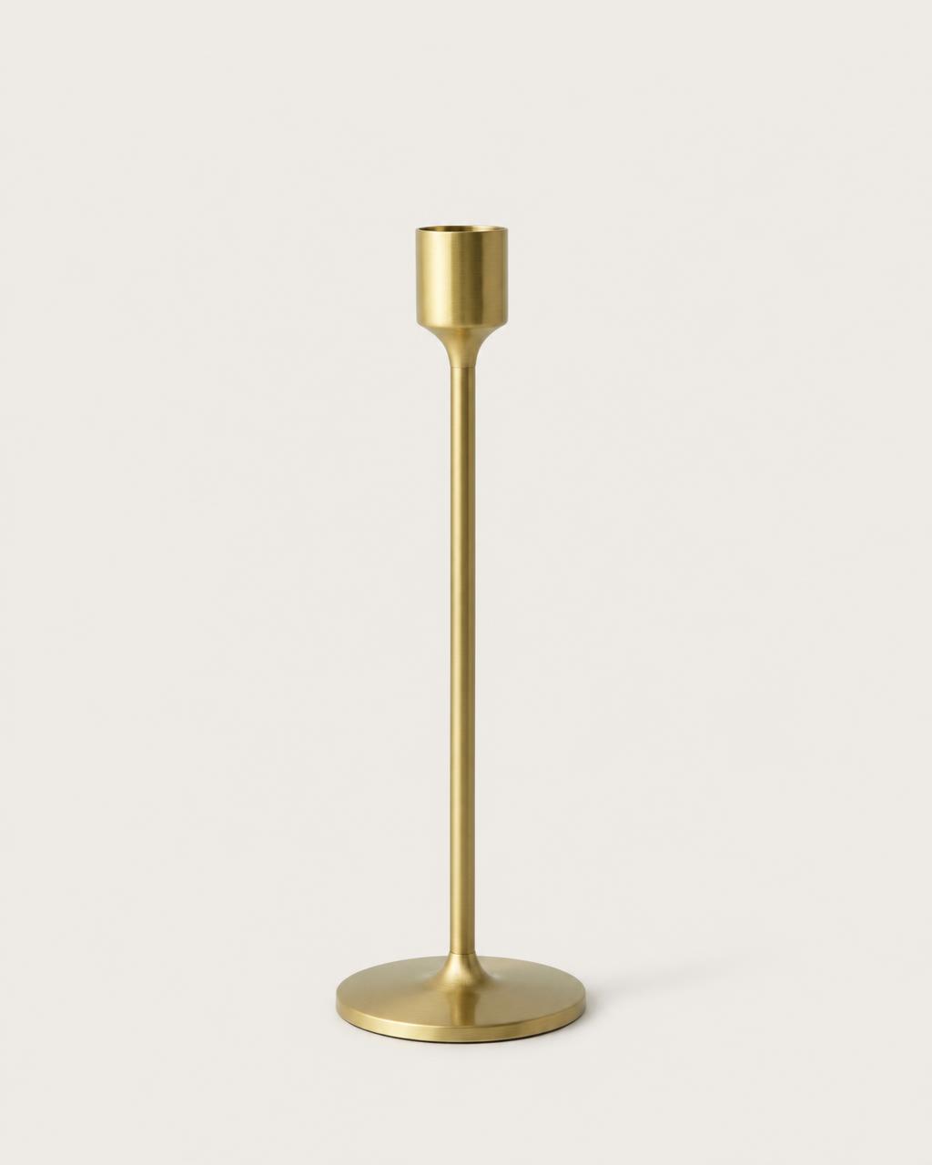 Slim brushed brass candleholder on a plain warm background